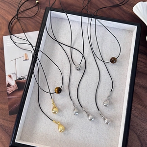 Vue détaillée de colliers cordon noir minimalistes avec divers pendentifs métalliques