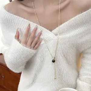 Close-up of elegant tiger eye stone necklace worn on a white mohair sweater