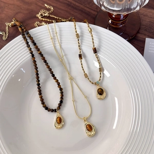 Three vintage tiger eye stone pendant necklaces with gold plating and beaded chain styles