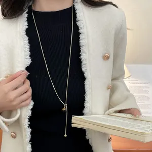 Detail of adjustable Y-shaped gold necklace with tiger eye stone bead on model