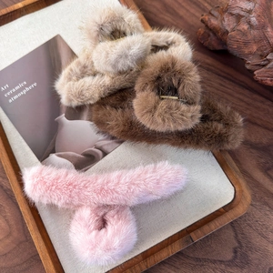 Eleganti mollette per capelli in peluche albicocca, caffè e rosa su vassoio in legno