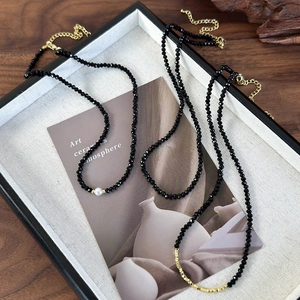 Elegant black crystal bead necklace set with white pearl and gold accents for layered styling