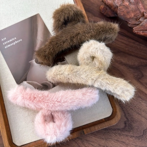 Dettaglio di fermagli per capelli in morbido peluche in colori autunnali