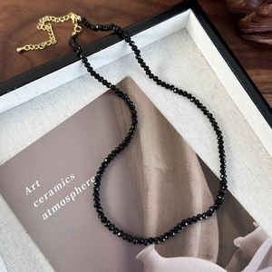 Detail of 3mm faceted black bead necklace with gold-plated lobster clasp and extension chain