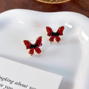 Macro view of vintage red butterfly earrings with black crystal and gold plating