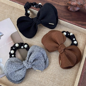 Three wool bow hair scrunchies with white pearls in charcoal black, brown, and grey colors