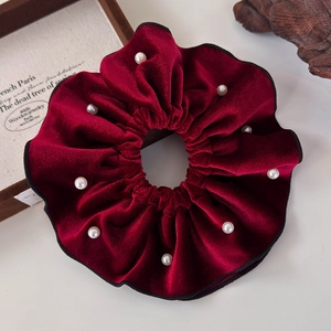 Close-up of vintage burgundy velvet scrunchie with delicate faux pearl embellishments