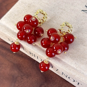 Close-up of vintage red berry cluster earrings with gold hammered metal and beads