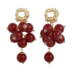 Vintage gold textured studs with dark red beaded grape clusters on a white background