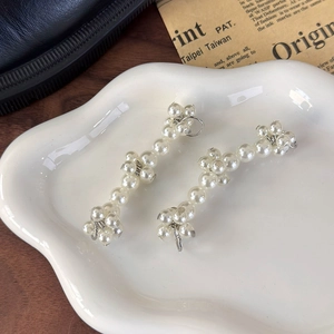 Detailed close-up of handmade pearl shoe charms for sneakers on a ceramic tray