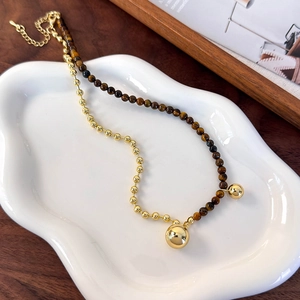 Close-up of dual-style beaded necklace with tiger eye stones and golden metal beads