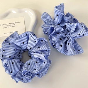 Close-up of blue striped heart pattern scrunchie set on a white ceramic tray