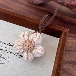 Détail d'une fleur tricotée main sur une pince à cheveux banane façon écaille
