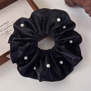 Detail shot of vintage black velvet scrunchie with elegant faux pearl embellishments
