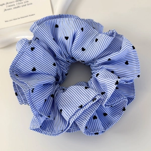 Detail of blue striped scrunchie with black heart pattern and four-layer ruffled fabric