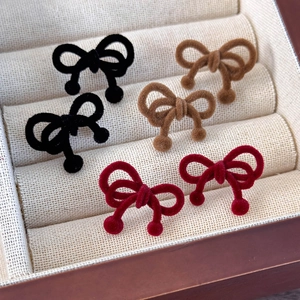 Three pairs of vintage velvet bow earrings in black, brown, and wine red colors