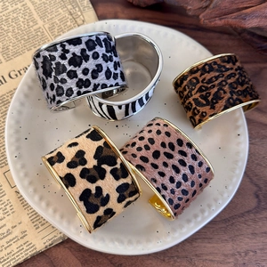 Chic animal print open bangles featuring leopard and zebra textures on elegant gold and silver metal