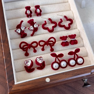Détail de boucles d'oreilles ours et fleurs rouges floquées avec strass et velours