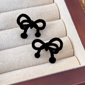 Detailed close-up of vintage black velvet bow earrings with small round ball accents