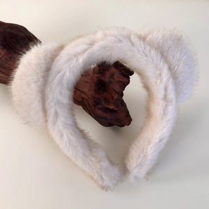 Gros plan de serre-têtes oreilles de chat en peluche blanche sur support en bois naturel