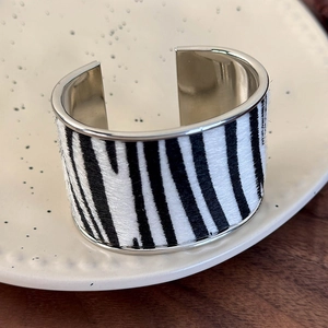 Detailed view of zebra print faux fur cuff bracelet with silver metal inner lining