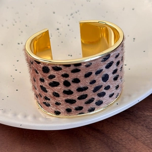Detailed view of the leopard print suede texture on the golden wide open cuff bracelet