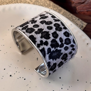 Close-up of wide leopard print bangle with faux fur inlay on polished silver metal base