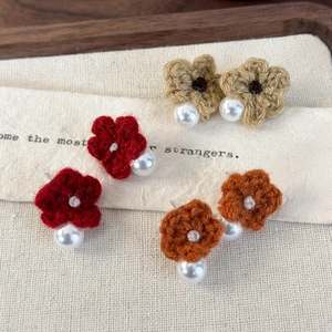Handmade crochet flower earrings with pearls in red, orange, and brown tones