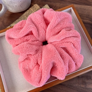Close-up of pink oversized fluffy towel scrunchie with soft coral fleece texture