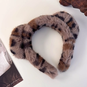 Détail rapproché du serre-tête en peluche léopard avec une texture douce en fausse fourrure