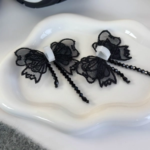 Détail des décorations de chaussures en dentelle noire papillon avec franges de perles