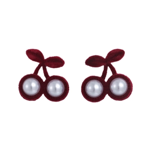 Détail de boucles d'oreilles cerises avec feuilles en velours rouge et perles