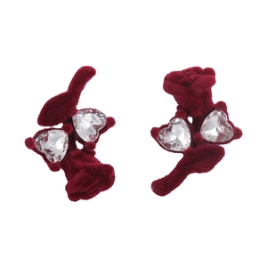 Détail de boucles d'oreilles rose floqué rouge avec des accents de cristal en forme de cœur