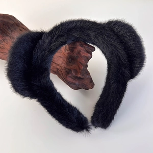 Détail de la texture en fourrure synthétique noire sur un serre-tête en peluche