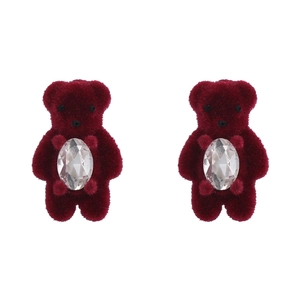 Détail macro de boucles d'oreilles ours rouge floqué avec cristal facetté et texture velours
