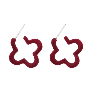 Gros plan détaillé des boucles d'oreilles fleurs floquées rouge foncé avec texture velours