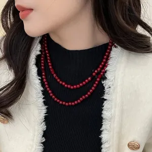 Détail montrant les perles rouge bordeaux d'un élégant collier à double rang de perles