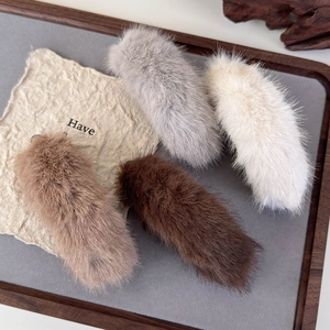 Plush faux fur banana hair clips in gray, cream, and brown for stylish winter hair styling