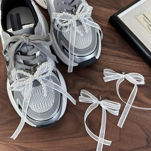 Ciondoli per scarpe con perle e fiocco in organza bianca su sneakers con chiusura in metallo