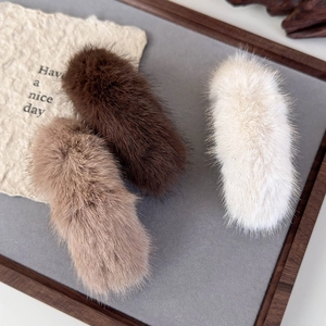 Detailed close-up of soft plush fur banana hair clips in brown and beige tones