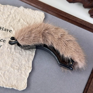 Detail shot of khaki faux fur banana hair clip with soft plush texture for winter
