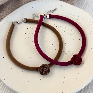 Collier choker rose en velours fait main en marron et bordeaux sur une plaque céramique
