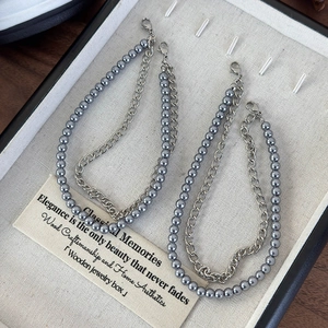 Detail of grey pearl and silver chain shoe decoration displayed in a wooden jewelry box