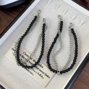 Detailed view of double-layer shoe chain charms with black beads and silver metal links
