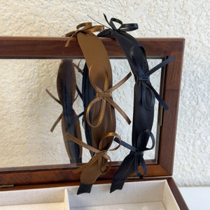 Detailed view of satin fabric headbands with elegant bows on a vintage wooden box