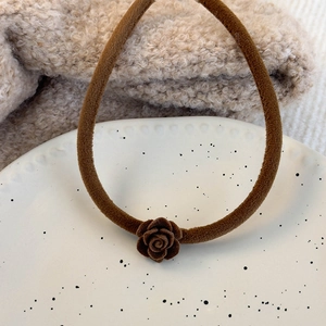 Vue détaillée du chouchou en velours marron foncé avec décoration de rose faite main
