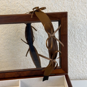 Detail of brown satin headband with three delicate bows on a vintage wooden box