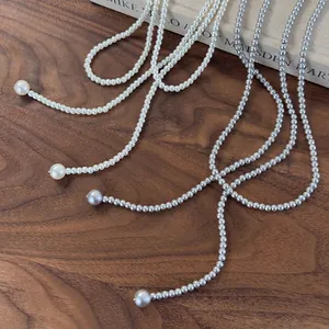 Elegant multi-layered long pearl necklace set in cream and silver-grey on walnut wood