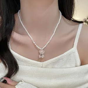 Gros plan sur le pendentif ours en velours et le collier de perles élégant