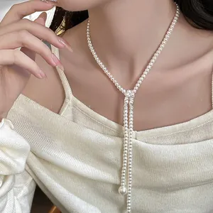 Detail of elegant long pearl lariat necklace featuring a large round pearl drop pendant